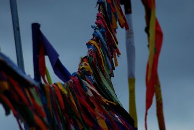 Low angle view of colorful flags hanging against sky