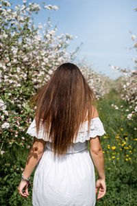 Rear view of woman standing against plants