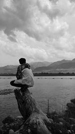 Rear view of couple on beach against sky