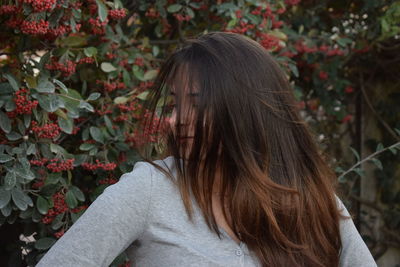 Woman with dyed hair standing by plant