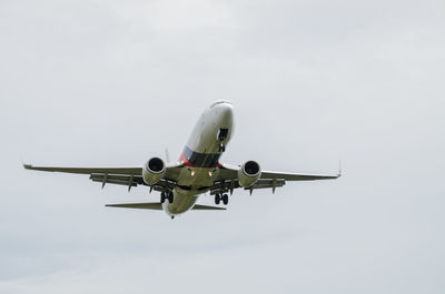 Low angle view of airplane in flight against sky