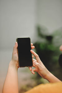 Cropped hands of woman using mobile phone