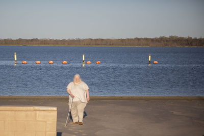 Blind woman walking away from a swimming area