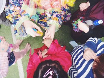 Directly above shot of clown stamping girl hand during birthday party