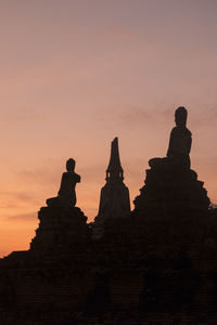 Low angel view of statues and temple at sunset