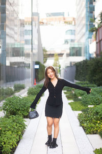 Full length of young woman exercising in city