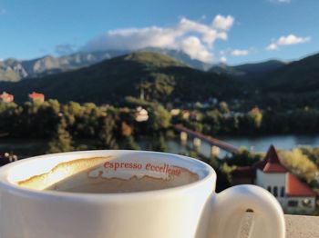 Close-up of coffee cup against mountains