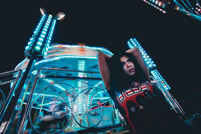 Low angle view portrait of illuminated ferris wheel at night