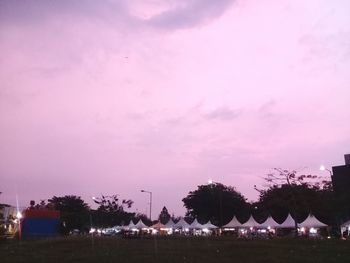 Panoramic view of buildings and trees against sky at dusk