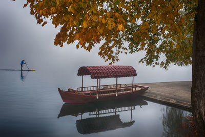 Gazebo by lake against sky during autumn