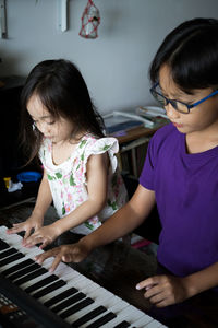 Happy kids playing piano at home