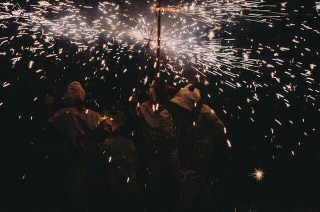 GROUP OF PEOPLE WATCHING FIREWORK DISPLAY