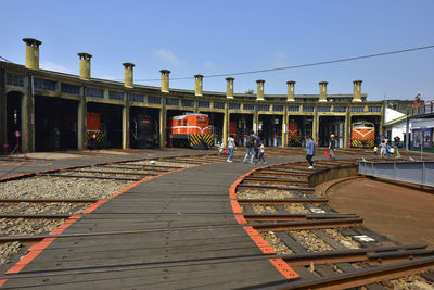 Railroad tracks in city against clear sky