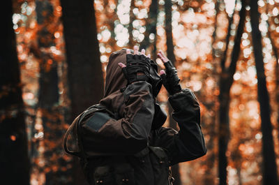 Midsection of person in forest during winter