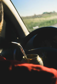 Close-up of hand on car against sky