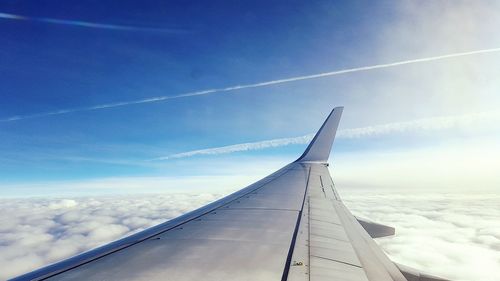 Cropped image of airplane flying over clouds