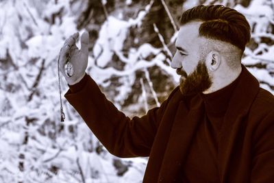 Portrait of young man standing in snow