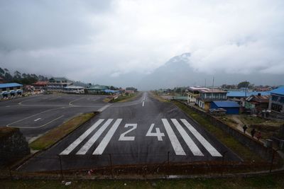 Road sign against cloudy sky