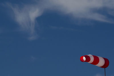 Low angle view of red flag against sky