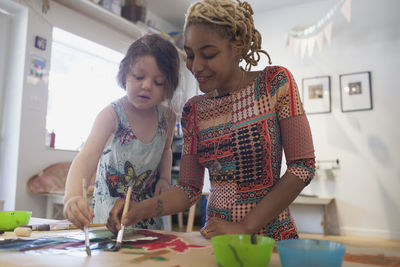 Smiling teacher and student painting in a classroom