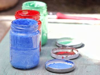 Close-up of watercolor paints in glass containers on table