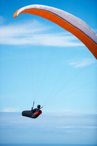 Low angle view of person paragliding against sky