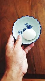 Close-up of hand holding cup of cake