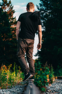 Rear view of man standing in forest