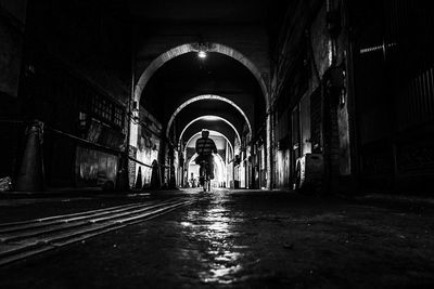 Rear view of man standing in illuminated building