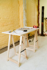 Blueprints, ear defenders, protection glasses and tools on architect workspace at construction site