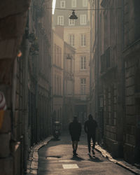 Rear view of people walking on street in city