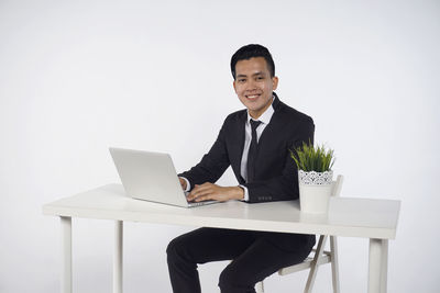 Man using mobile phone while sitting on table