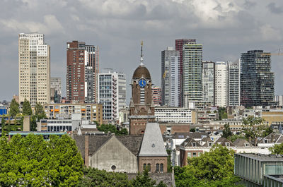 The tower of arminius church in front of the modern highrise of the city center