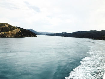 Scenic view of sea and mountains against sky