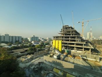 Construction site against buildings in city against sky