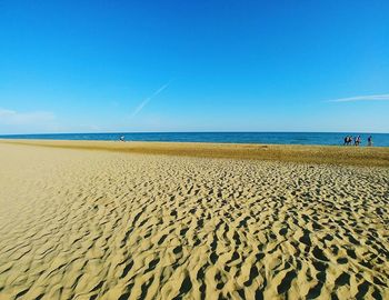 Scenic view of beach against clear blue sky