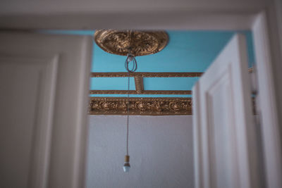 Low angle view of electric lamp hanging on ceiling at home