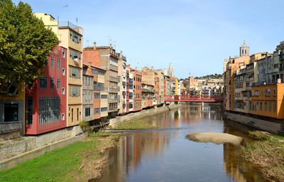 Canal amidst houses in town against clear sky