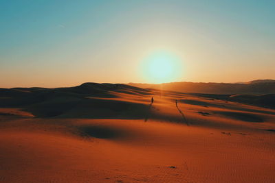 Scenic view of desert against sky during sunset