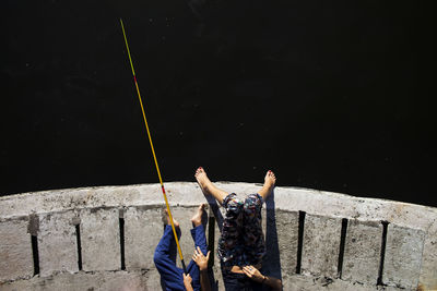 Low section of people fishing by sea