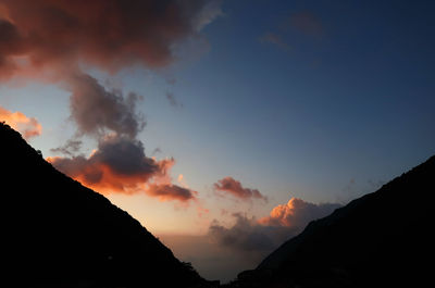 Low angle view of silhouette mountains against sky at sunset