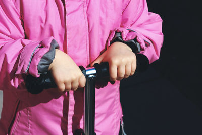 Midsection of man holding hands against pink background