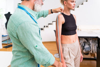 Fashion designer taking measurement at studio