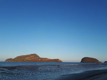Scenic view of sea against clear blue sky