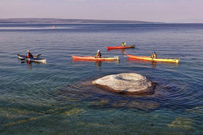 People on boat in sea against sky