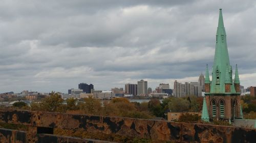 View of cityscape against cloudy sky