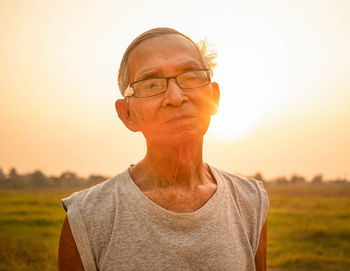 Portrait of man on field against sky during sunset