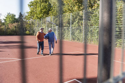 Two fit seniors having fun on a basketball field