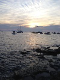 Scenic view of sea against cloudy sky at sunset