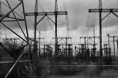 Low angle view of electricity pylon on field against sky